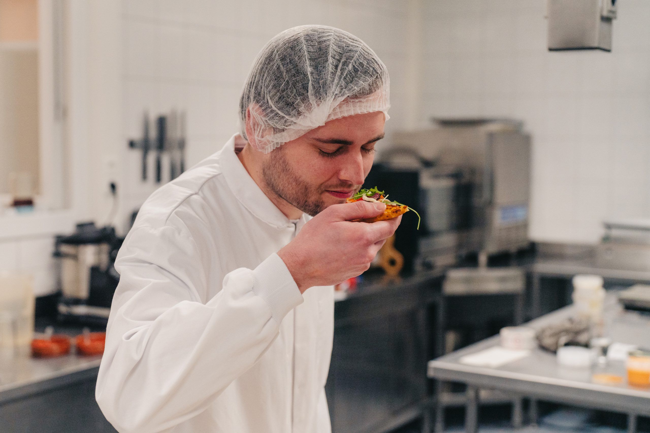 Employee smells a piece of pizza